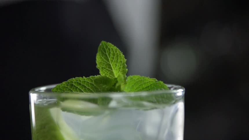 A glass is displayed with garnish on top