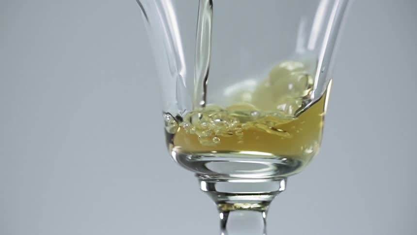 A golden liquid being poured into a glass