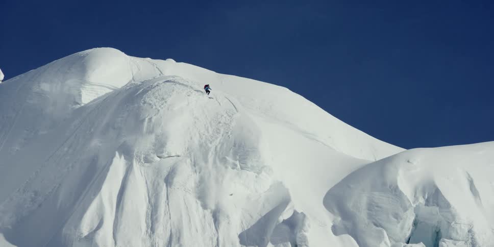 A skier starts a small avalanche on a mountain