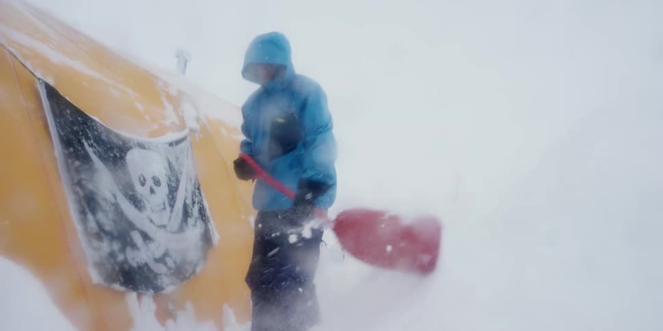 The person shovels the snow in a blizzard