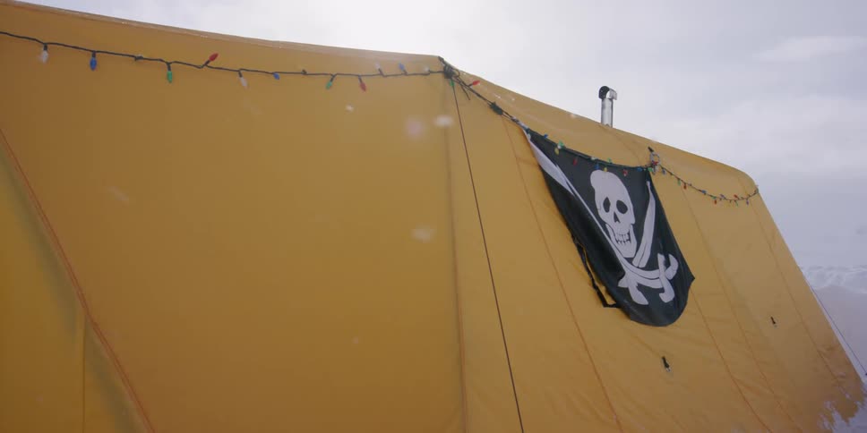 A tent with a skull on it in the snow