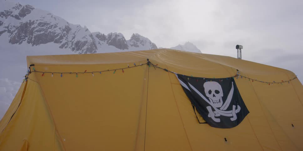 A tent with a pirate flag in the mountains