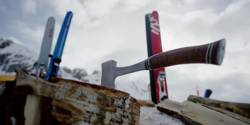 An ax sits in front of the skis