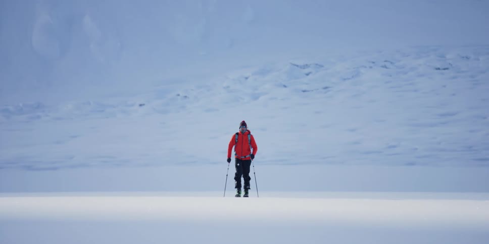 Skier trekking across the snow in slow motion