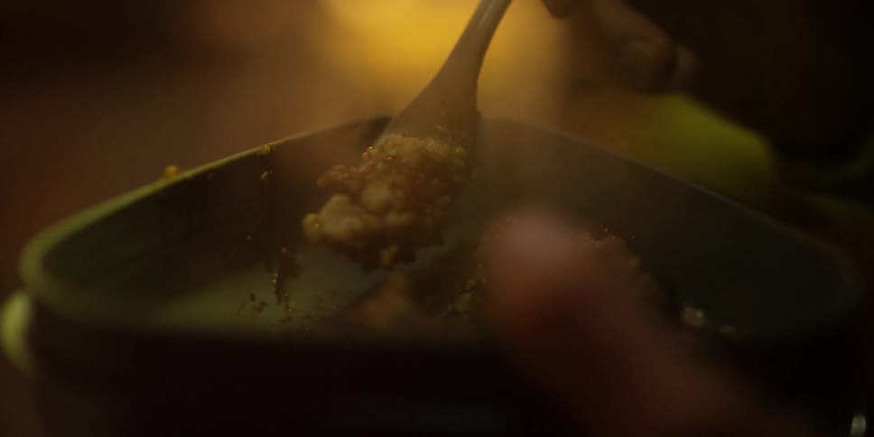 A person is eating steaming food from a bowl
