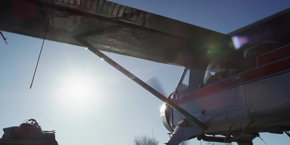 An airplane with its propeller spinning with the sky in the background