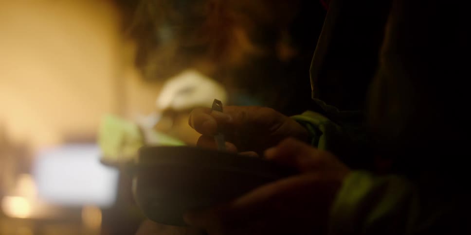 Two people sit and eat out of bowls with steam rising from them