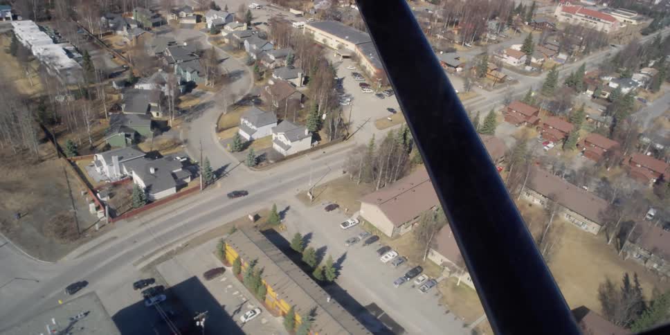 An airplane flies over a neighborhood