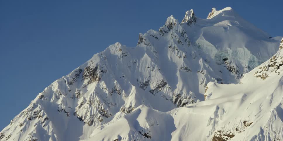 Shadows on the snow capped mountain against the blue sky on a sunny day