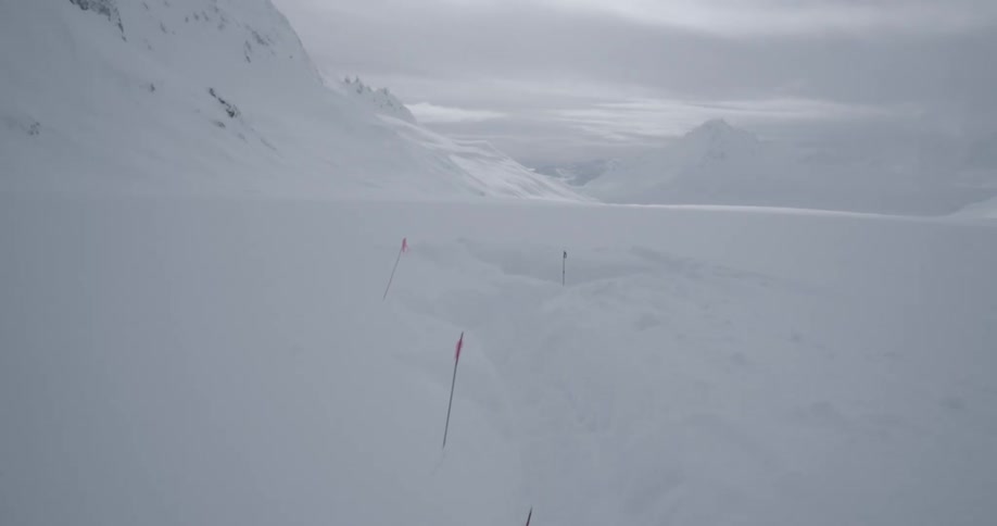 Aerial push past a tent into snow covered glacial area