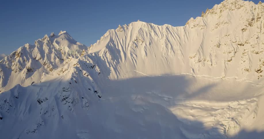 Aerial of a snow covered mountain ridge on a cold morning