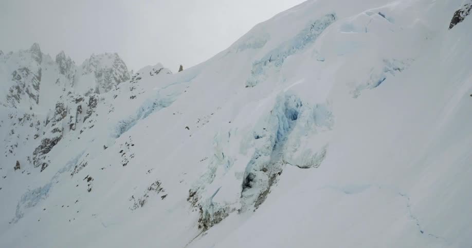 Aerial push in on snow covered glacier