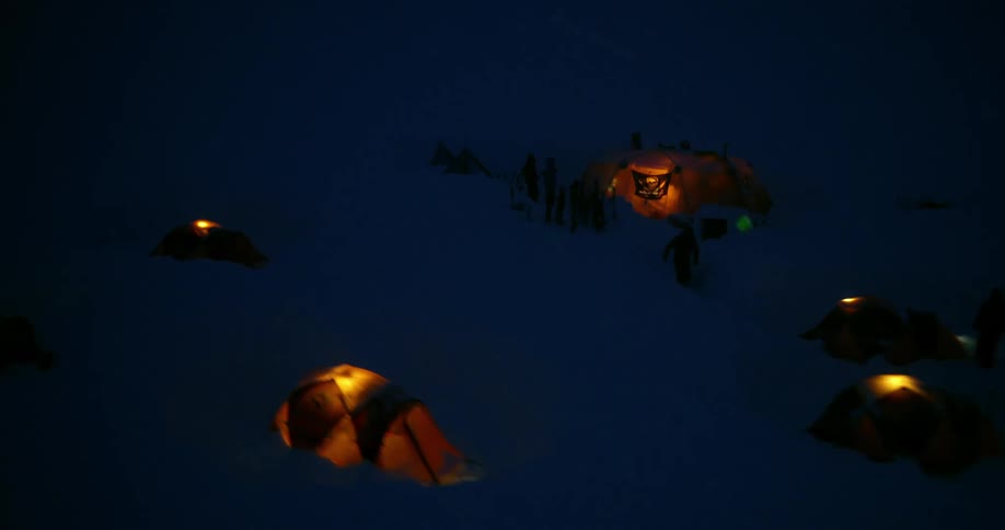 Aerial of lit tents at night in winter