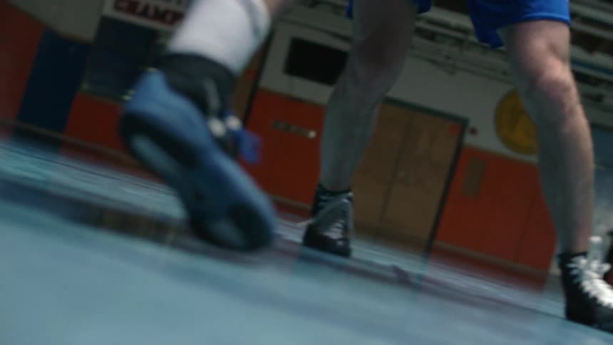 Two people are wrestling in a gym