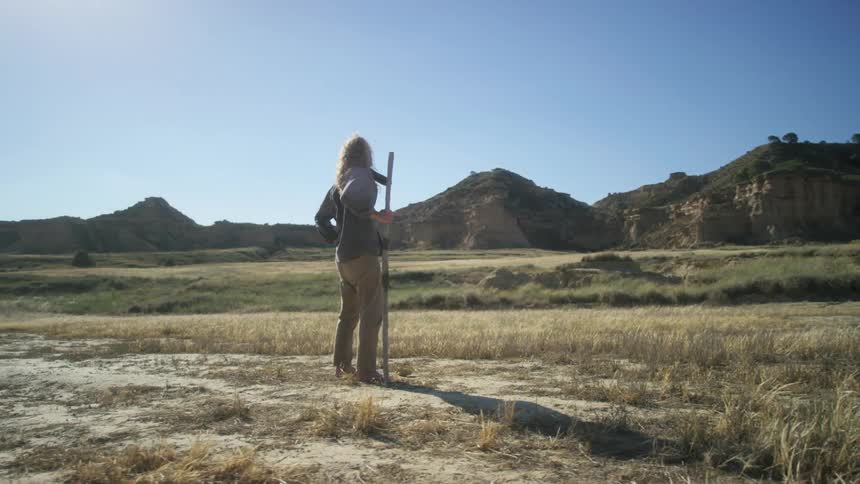 The man walks near the mountains