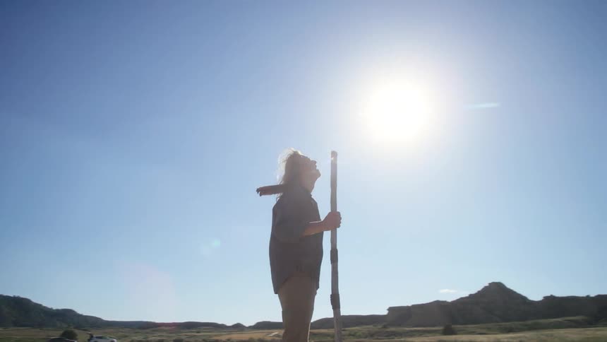 A man stands on the field on a sunny day