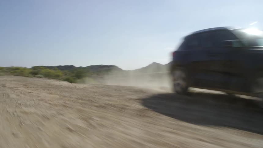 A car drives onto the dirt road