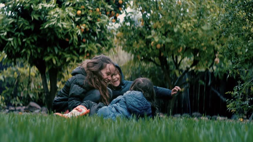 Children sitting on the grass play and laugh in the garden