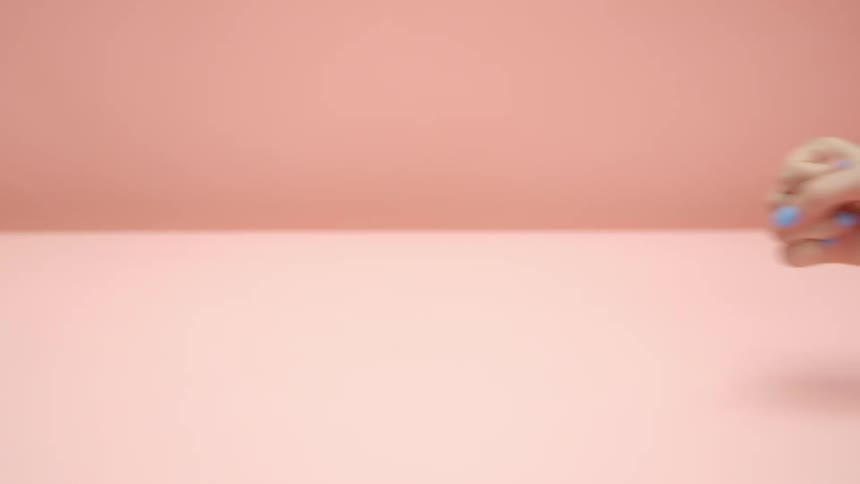 A womans hand punching a clock with a pink background