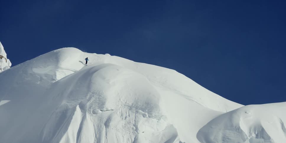 A person skis above a steep slope