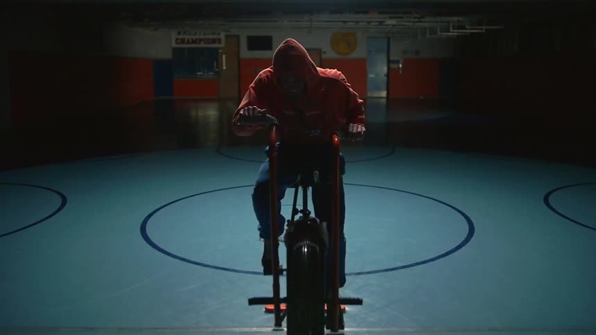 A man is riding a stationary bike in a gym