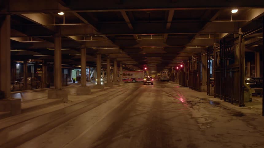 Cars and trucks travel beneath a structure
