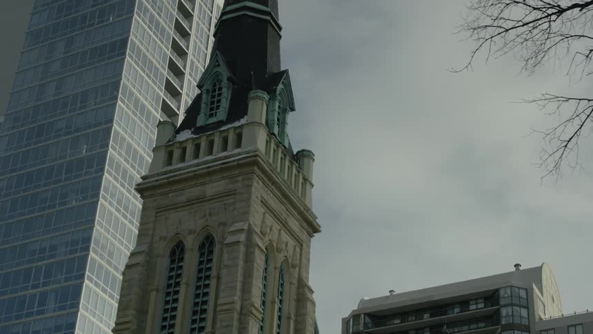 Tall buildings line the sky on a cloudy day