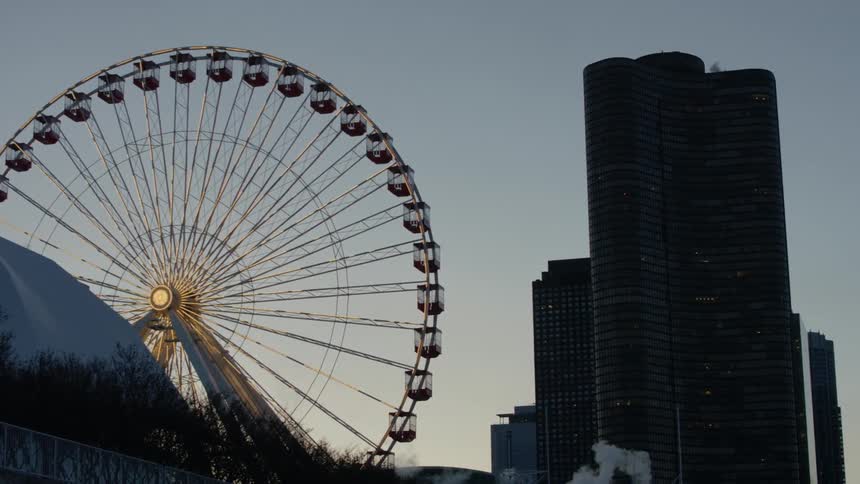 A ferris wheel stands next to a skyscraper
