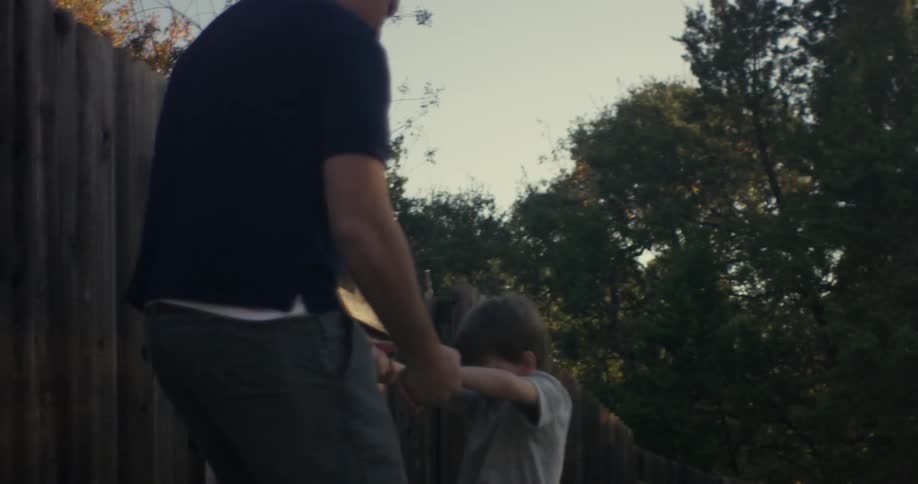 A child runs over to a man and he flips him over