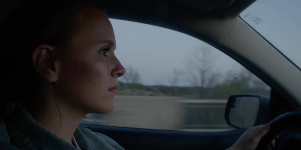 Side view of a woman driving her car