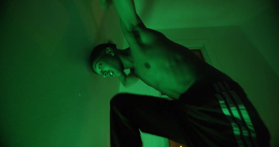 A man dances next to a window in a room