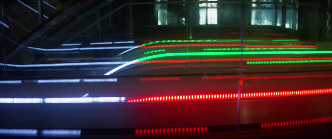 Red green and white lights illuminate an escalator