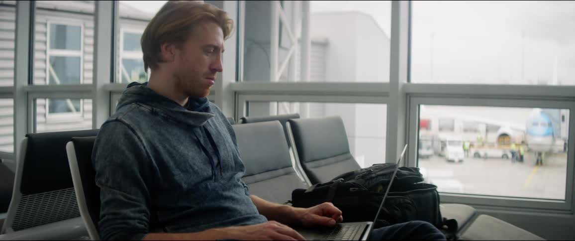Man uses a laptop in the airport waiting room
