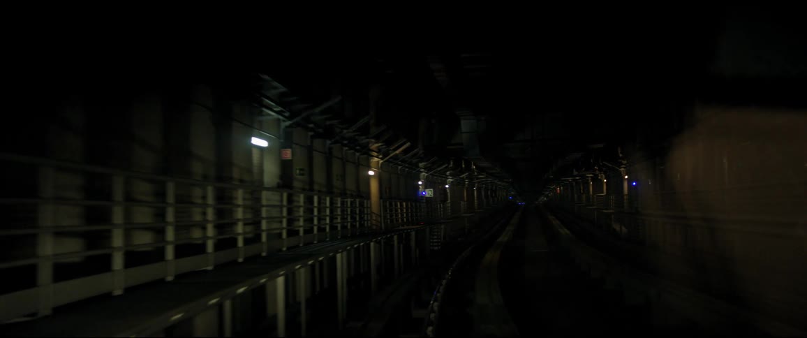 Train track leads through tunnel in the dark