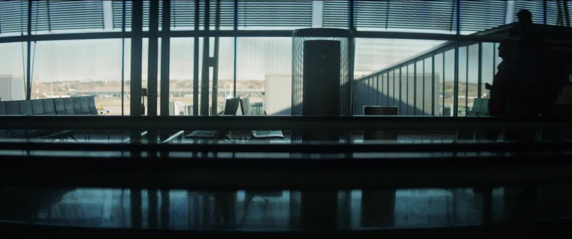 Several people walk through an airport