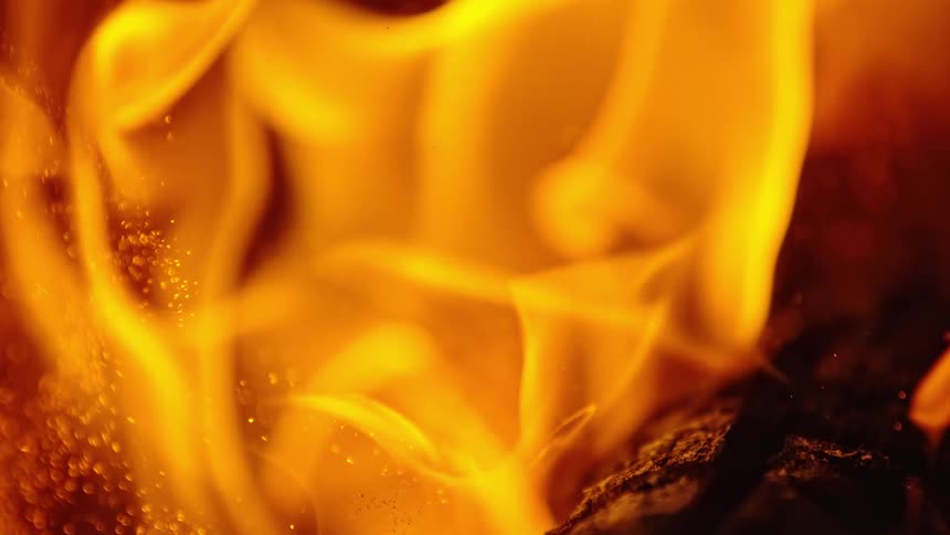 The flames lift above the wood