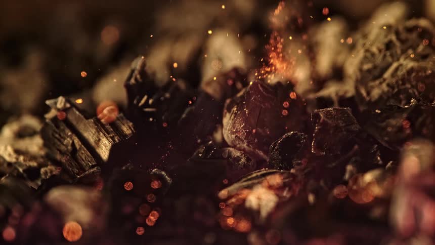 Fire ignites in charcoal throwing up sparks