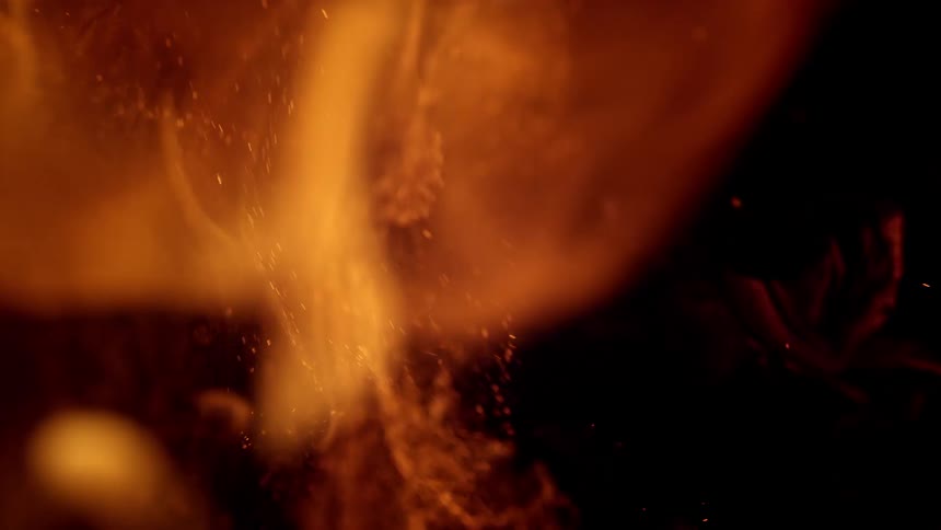 A flame billows against a black background
