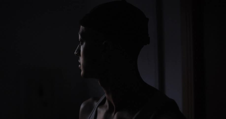 Man looks to his right as he stands near a wall