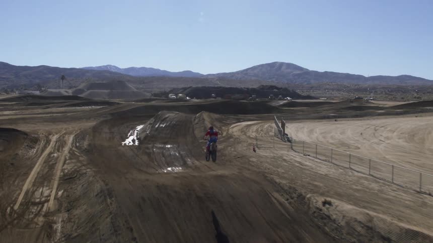 A person is riding a dirt bike on dirt road