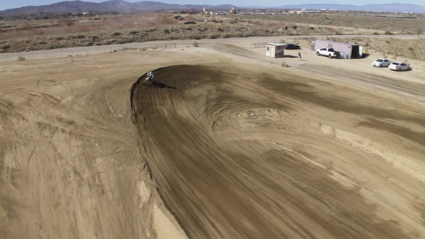 A motorcyclist races around a dirt track