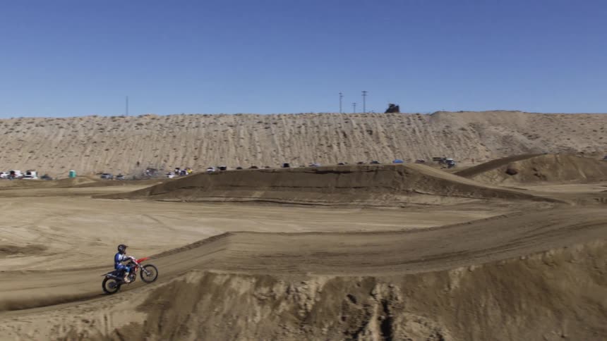 Racers compete on a dirt bike track in the desert
