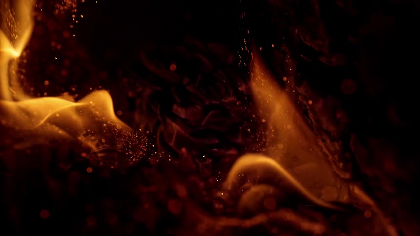 A fire burns with sparks and embers flying up