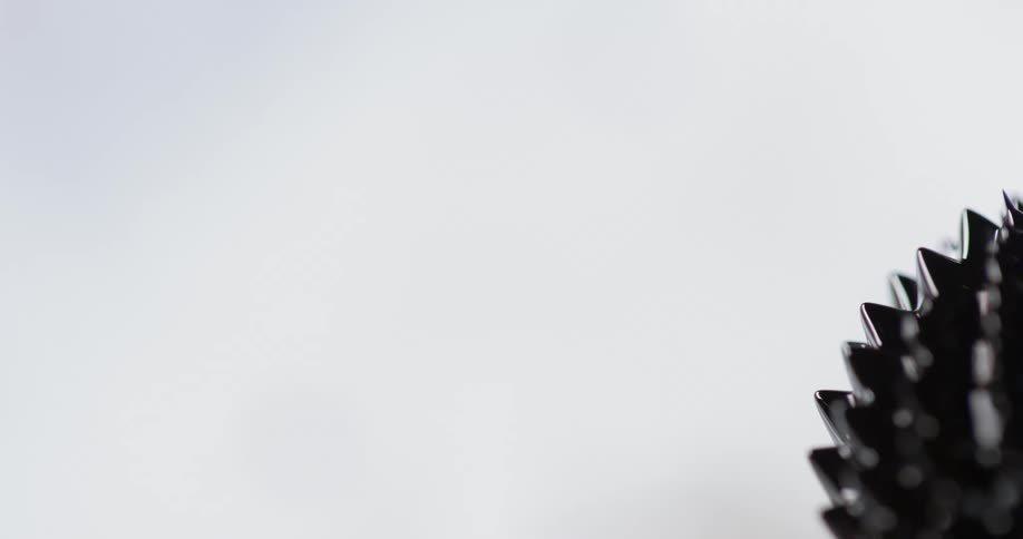 A round object with spikes turns in front of a white background