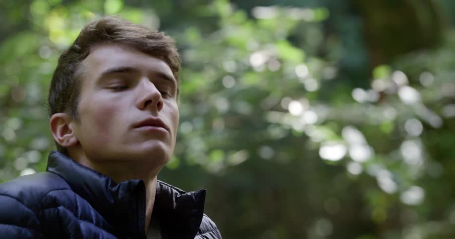 Man thinks about something carefully and looks around in the dense forest