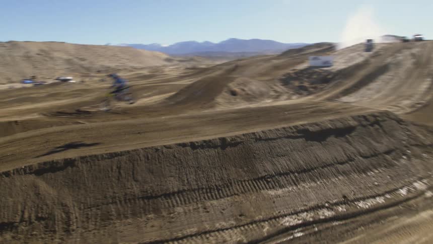 People driving motorcycles on a motocross track