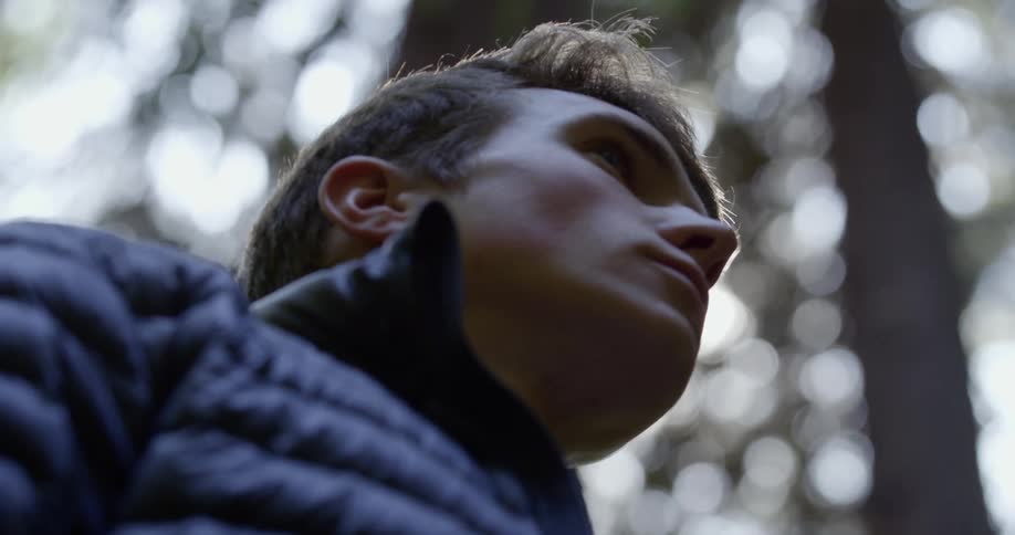 Man stands and looks around in the forest