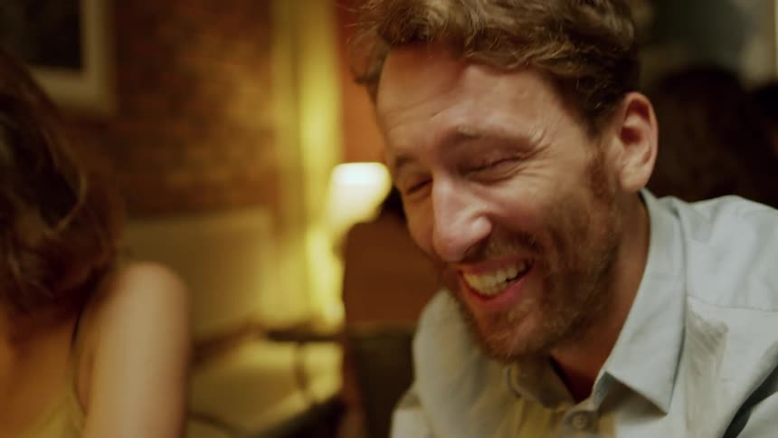 Man and woman sit near each other laughing