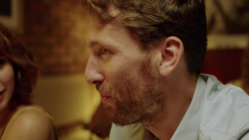 Couple sits at the table and talks to their friends in a cafe