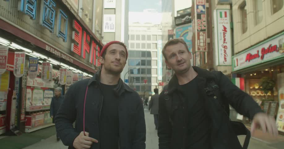 Two tourists walk down the city street talking